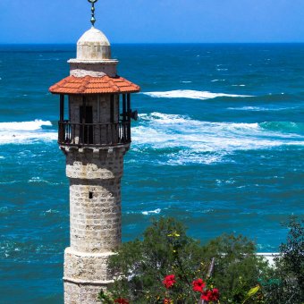 The minaret of the mosque in old Jaffa   on blue sky and  Mediterranean sea background